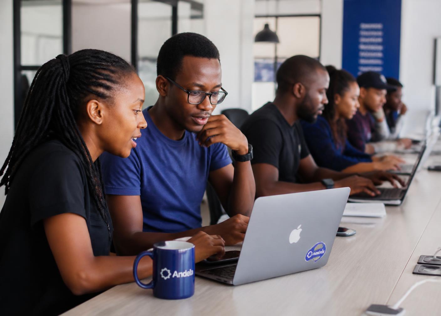 Young professionals learning together on laptops in a Nairobi tech classroom